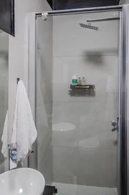 a bathroom with a shower with a sink and a toilet at Trendy Cottage Hideaway in Cape Town
