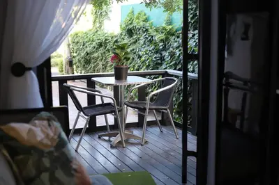 a table and chairs on a porch with a potted plant at Trendy Cottage Hideaway in Cape Town