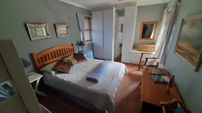 a bedroom with a bed and a table in it at Betty's Bay Holiday home in Clareport