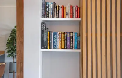 a book shelf filled with books next to a wall at Searenity Sands in Strand