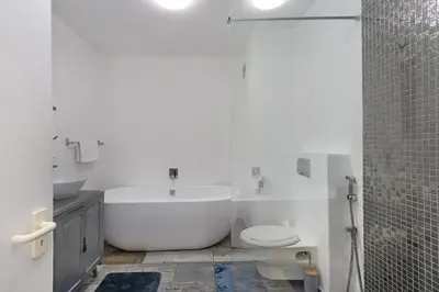 a bathroom with a tub and a toilet and a shower at Sea Spray AG04 in Bloubergstrand