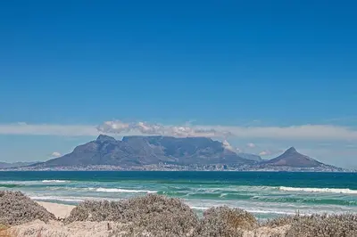 a view of the ocean with a mountain in the background at Sea Spray AG04 in Bloubergstrand