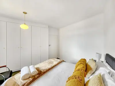 a bedroom with a bed with white walls at Pool, Gym, self check-in,Parking in Cape Town