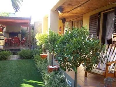 a garden with potted trees in pots on a house at Dai Heka Guest House in Strand