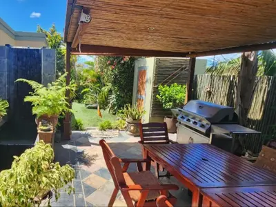 a patio with a picnic table and a grill at Dai Heka Guest House in Strand