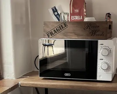 a microwave on a table with a wooden box on top at Kabana Family Home and Guest House in Cape Town