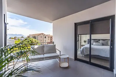 a bedroom with a bed and a large window at Chic Modern 2 bedroom beachfront with views, 6 Blue Tides in Bloubergstrand