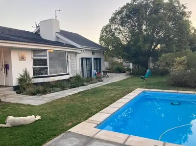 a house with a blue swimming pool in the yard at Morningside Studio apartment, load shedding proof in Cape Town