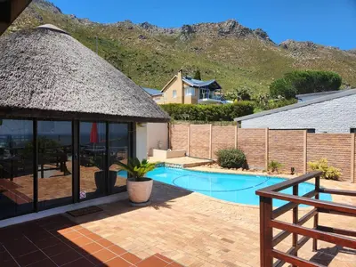 a house with a pool and a straw roof at Thys' Place in Cape Town