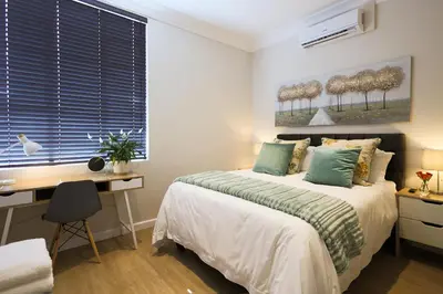 a bedroom with a bed and a desk and a window at 505 La Roche, Paarl in Paarl