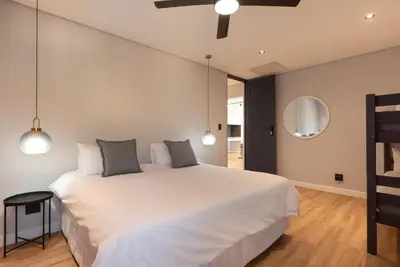 a bedroom with a large white bed and a mirror at Villa Paradys - Serviced in Stellenbosch