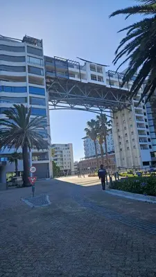 a person walking under a bridge in front of a building at SS Luxury Apartments in Cape Town