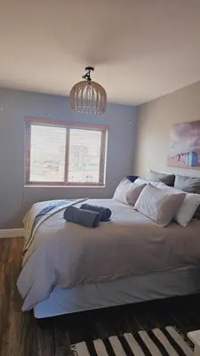 a bedroom with a large bed with a chandelier at SS Luxury Apartments in Cape Town
