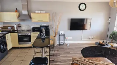 a kitchen with a table and a clock on the wall at SS Luxury Apartments in Cape Town