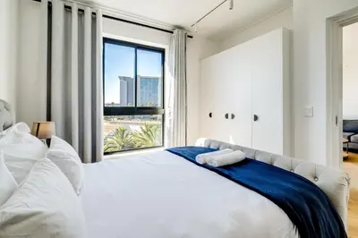 a bedroom with a large bed with a large window at Belina - Nine Palms Premier in Cape Town
