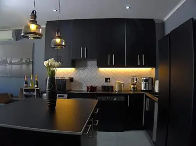 a kitchen with black cabinets and a black counter top at Sitari County Estate - The Most Iconic Estate in Cape Town