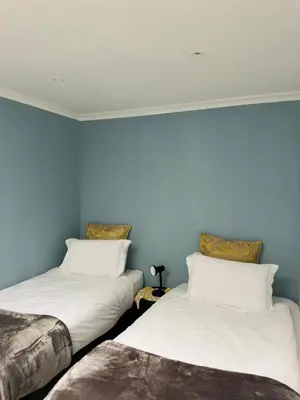two beds in a room with blue walls at Entertainers delight near the beach & wine routes in Cape Town