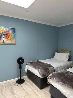 a bedroom with two beds and a painting on the wall at Entertainers delight near the beach & wine routes in Cape Town