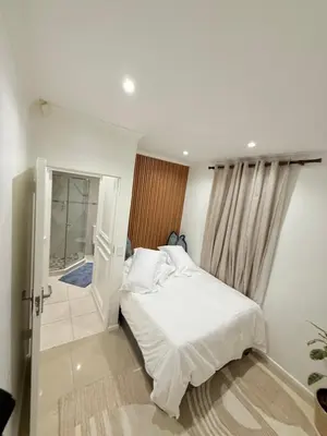 a bedroom with a white bed and a glass door at DOMIN LUXURY SUITES in Cape Town