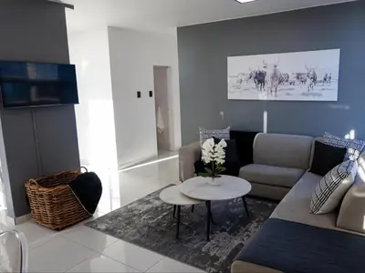 a living room with a couch and a table at St Tropez Beachfront 101 in Strand