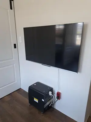 a television hanging on a wall with a briefcase under it at The Stetson - Paarl - Self Catering Apartment in Paarl
