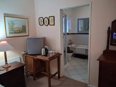 a room with a desk with a television and a bathroom at Marinda's B&B in Cape Town