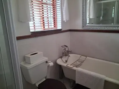 a bathroom with a tub and a toilet and a sink at Marinda's B&B in Cape Town