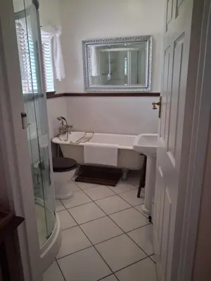 a white bathroom with a tub and a sink at Marinda's B&B in Cape Town