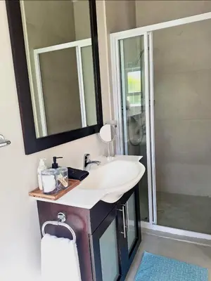 a bathroom with a sink and a shower at Spray Villa Bloubergstrand with hot tub and close to the beach in Bloubergstrand