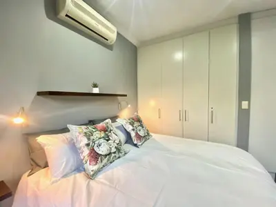 a bedroom with a white bed with pillows on it at Studio 23 @ Huis Piron. The Heart of Stellenbosch. in Stellenbosch