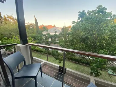 a balcony with a chair and a view of trees at Studio 23 @ Huis Piron. The Heart of Stellenbosch. in Stellenbosch