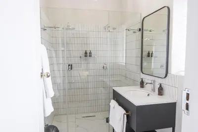 a white bathroom with a sink and a mirror at Laborie Jonkershuis in Paarl