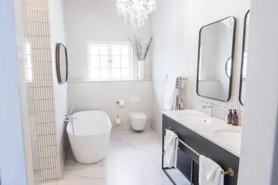 a white bathroom with a sink and a toilet at Laborie Jonkershuis in Paarl