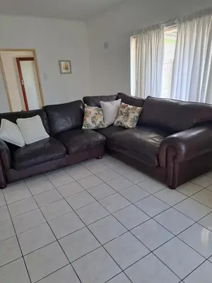 a black leather couch in a living room at A cosy home in Hermanus in Hermanus