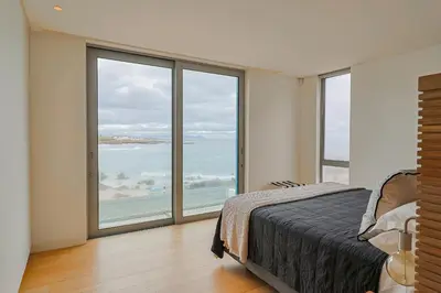 a bedroom with a bed and a view of the ocean at 91 Atlantic Drive in Hermanus