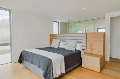 a bedroom with a large bed and a mirror at 91 Atlantic Drive in Hermanus