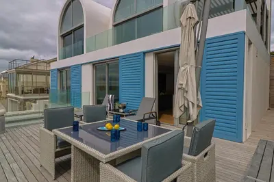 a patio with a table and chairs and an umbrella at 91 Atlantic Drive in Hermanus
