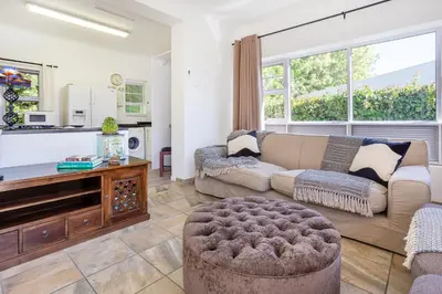 a living room with a couch and a piano at 55 MainStay in Hermanus
