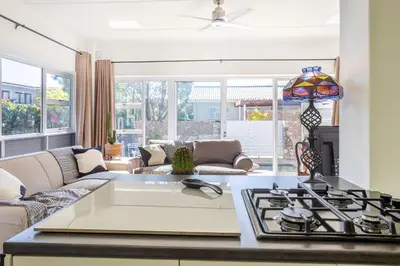 a kitchen with a stove and a living room at 55 MainStay in Hermanus