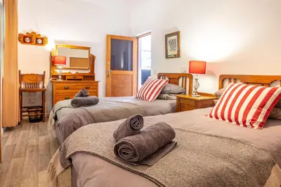 a bedroom with three beds with towels on them at 55 MainStay in Hermanus