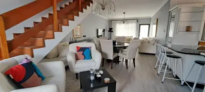 a living room with a staircase and a dining room at Blouberg Beach Villa in Cape Town