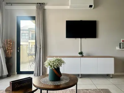 a living room with a vase of flowers on a table at The CoziPlace One in Cape Town