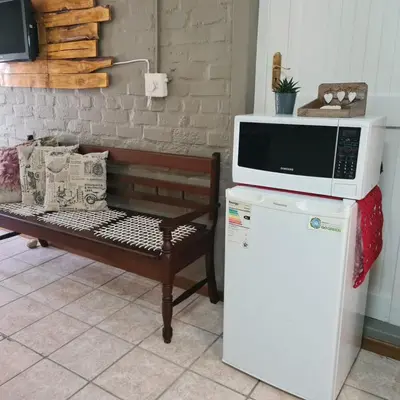 a microwave on top of a refrigerator next to a bench at Mads Place in Cape Town