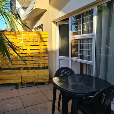 a black table and chairs on a patio at Mads Place in Cape Town