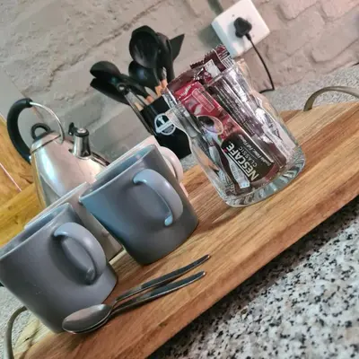 a wooden cutting board with utensils and a blender at Mads Place in Cape Town