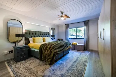 a bedroom with a large bed and a mirror at Florie se Huis in Paarl