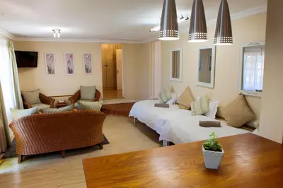 a living room with two beds and a table at Skilpadvlei Wine Farm in Stellenbosch