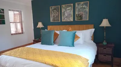 a bedroom with a bed with blue and white pillows at d'Vine Maison in Franschhoek