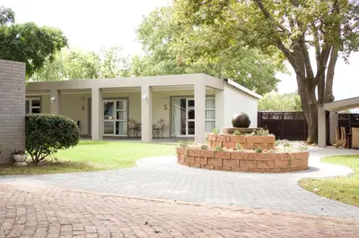 a house with a statue in the middle of a driveway at Nuwerus Lodge Paarl in Paarl