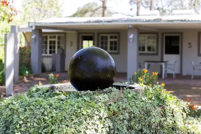 a house with a statue in front of a yard at Nuwerus Lodge Paarl in Paarl
